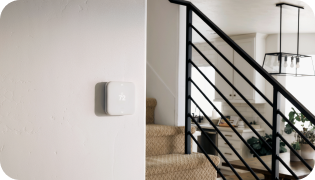 Vivint Smart Thermostat on a wall next to a staircase