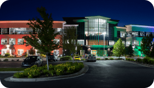 Vivint building lit up at night with orange, green, and blue lights