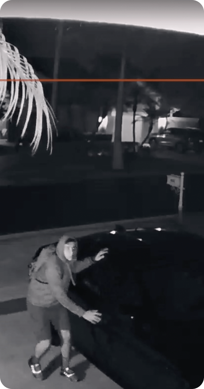 Vivint outdoor camera view of a man approaching a car at night