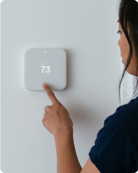 Person lowering the temperature on the Smart Thermostat.