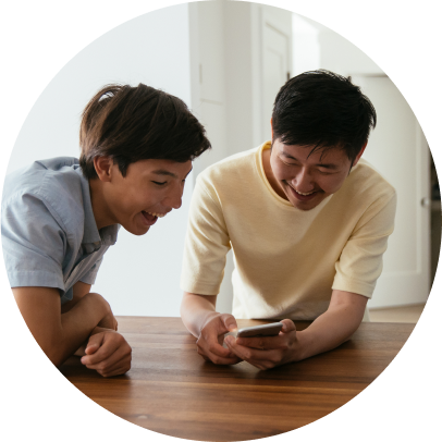 Two boys talking into a phone