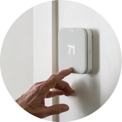 Person adjusting Thermostat on the wall