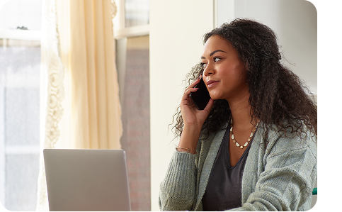 a woman sits next to the window, talking on a phone