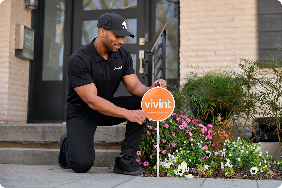 a Vivint rep installing Vivint yard sign outside of a house