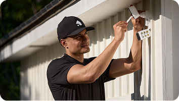 a Vivint representative installing an outdoor camera