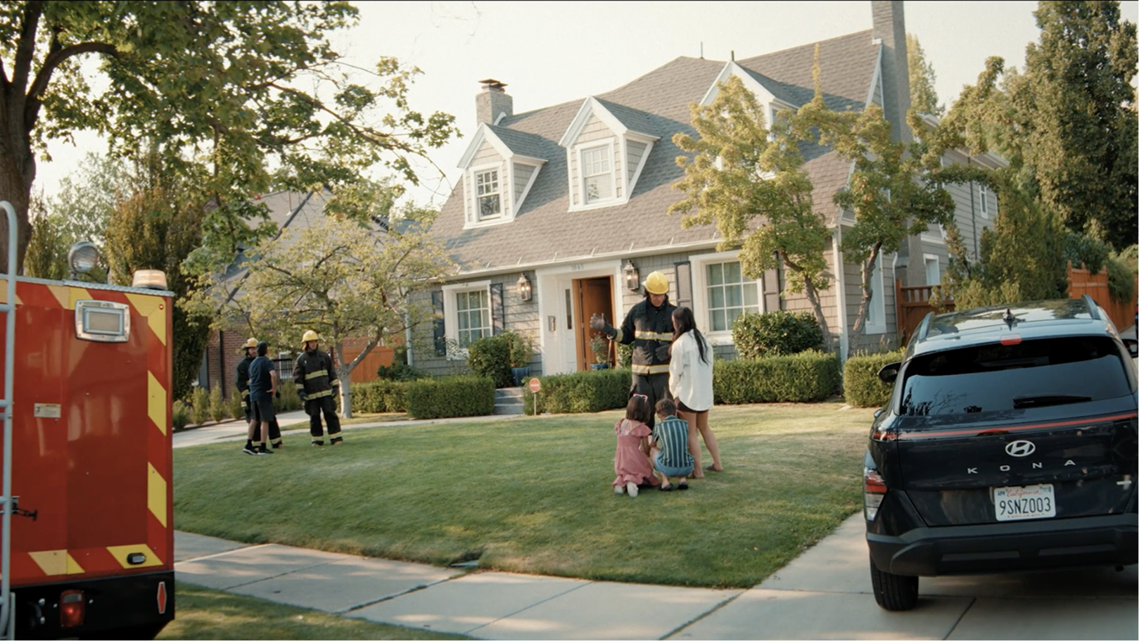 Firefighter helping a family at their front lawn