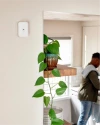 Glass break sensor on the wall with a man walking by in the background