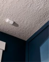 Vivint glass break sensor on the ceiling next to a window