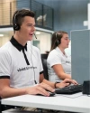Two Vivint representatives with headsets at Vivint monitoring center, talking to customers