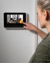 a woman using Vivint smart hub on a wall