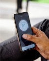 a hand adjusting temperature through Vivint thermostat on a phone