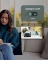 a woman looking at her phone with a notification from Vivint, saying "your garage door is open" 