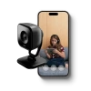 Vivint Indoor Camera Pro next to a phone showing a girl who's looking at an IPad on a couch