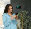 Woman checking her smartphone with a Smart Hub Pro 2 in the background