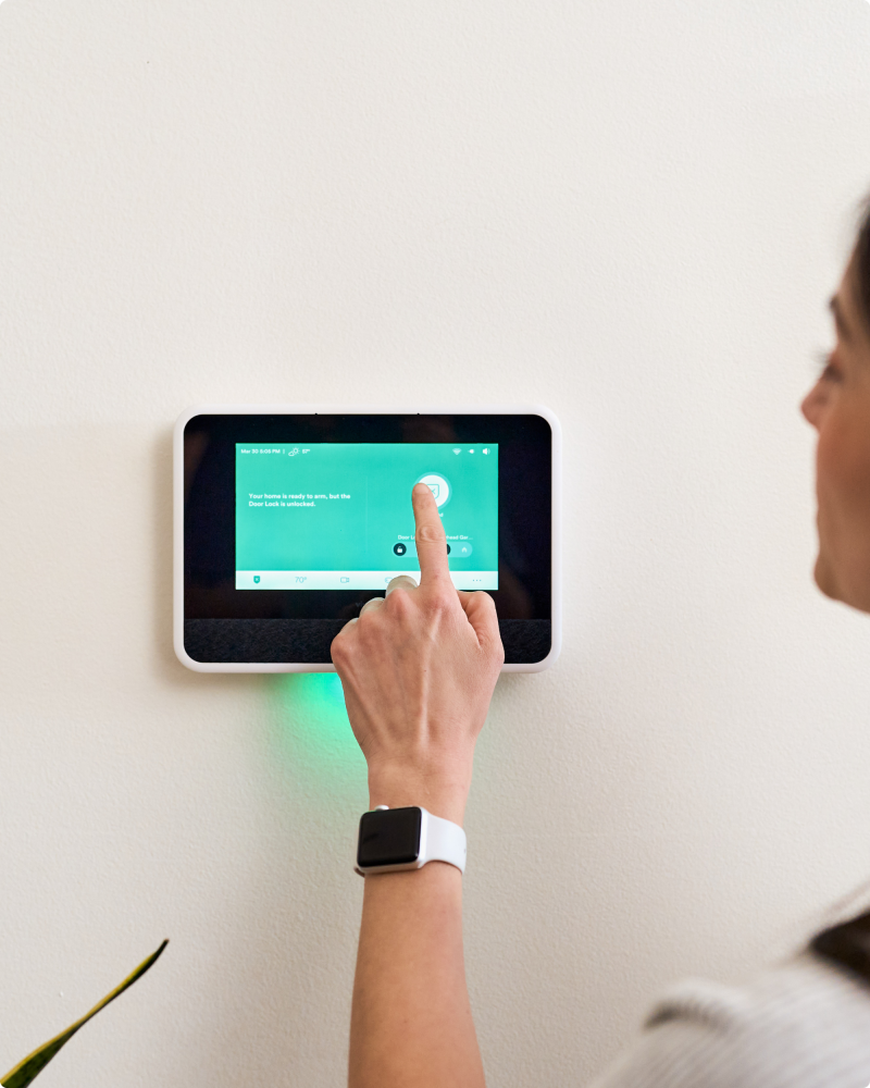 A person using Vivint smart hub on the wall