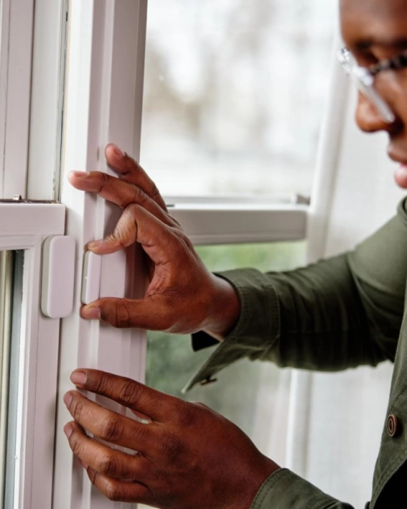 a person using Vivint window sensor installed on a window