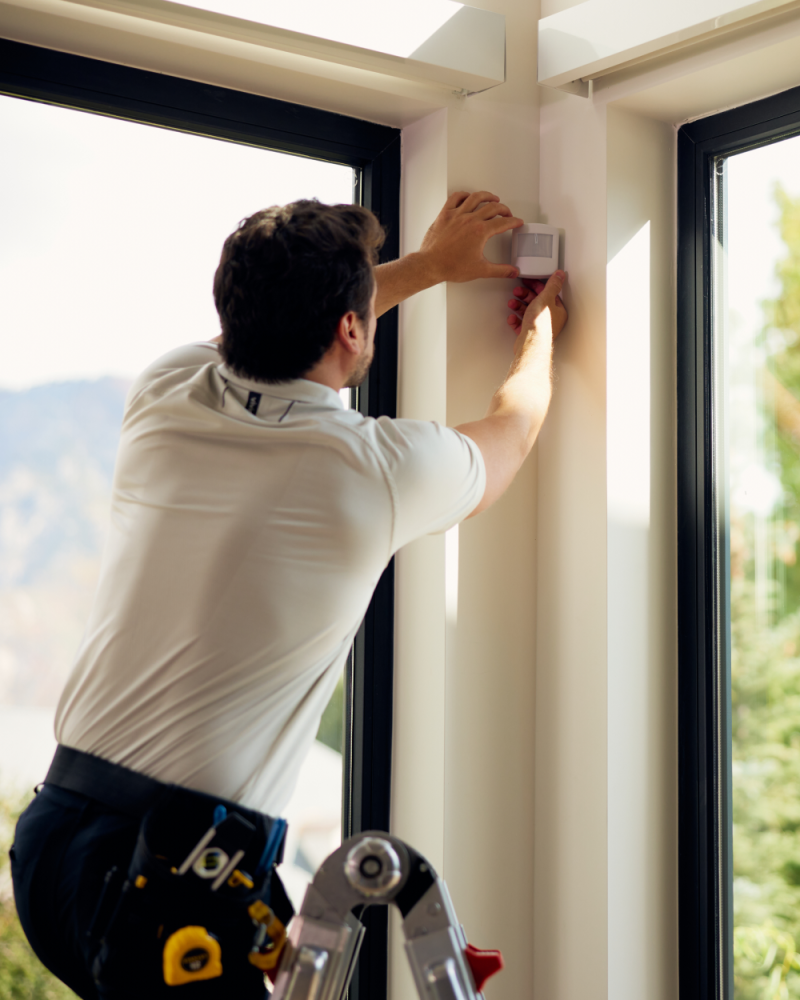 A Vivint rep installing a motion sensor next to the windows