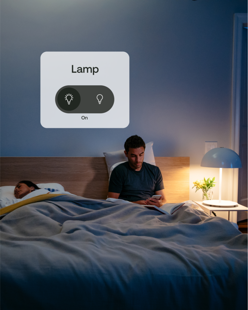 A man in bed next to a lamp with a on/off switch view from his phone