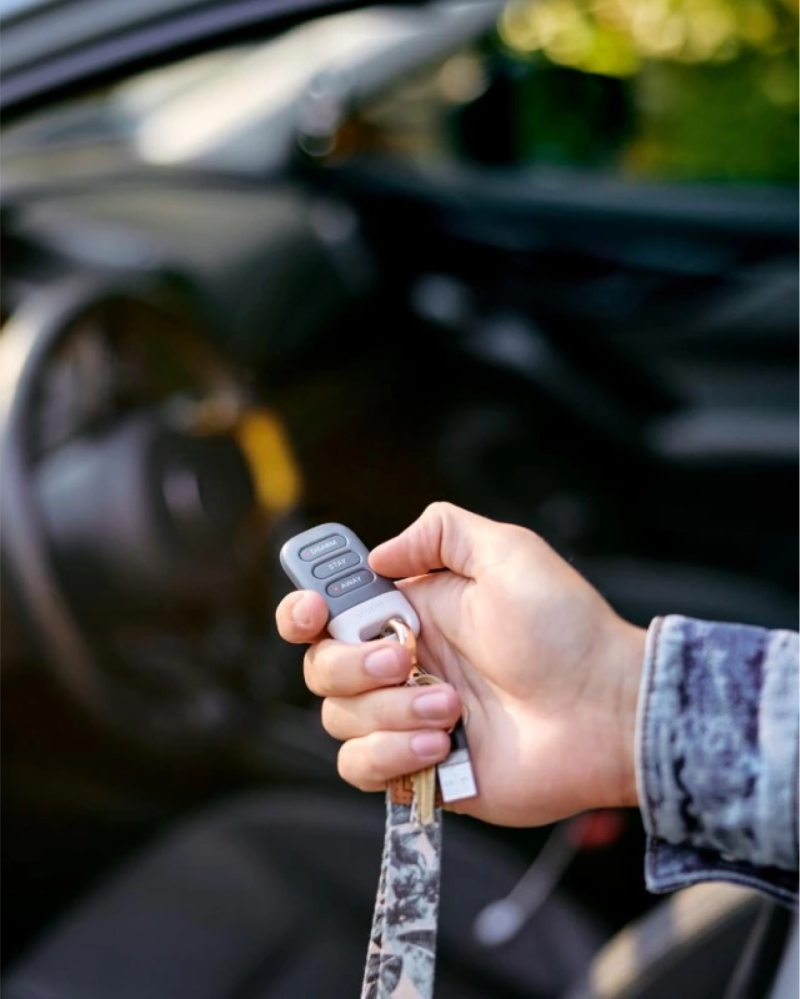 Person in their car holding up a Vivint Key Fob