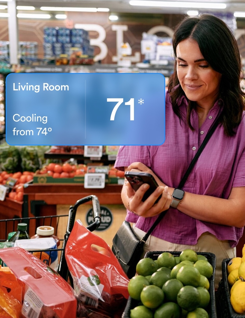 Woman checking home temperature on vivint app
