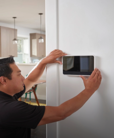 Profesional de hogar inteligente instalando una central inteligente en la pared