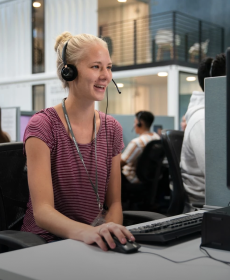 Representante de vigilancia con auriculares sentado frente a la computadora