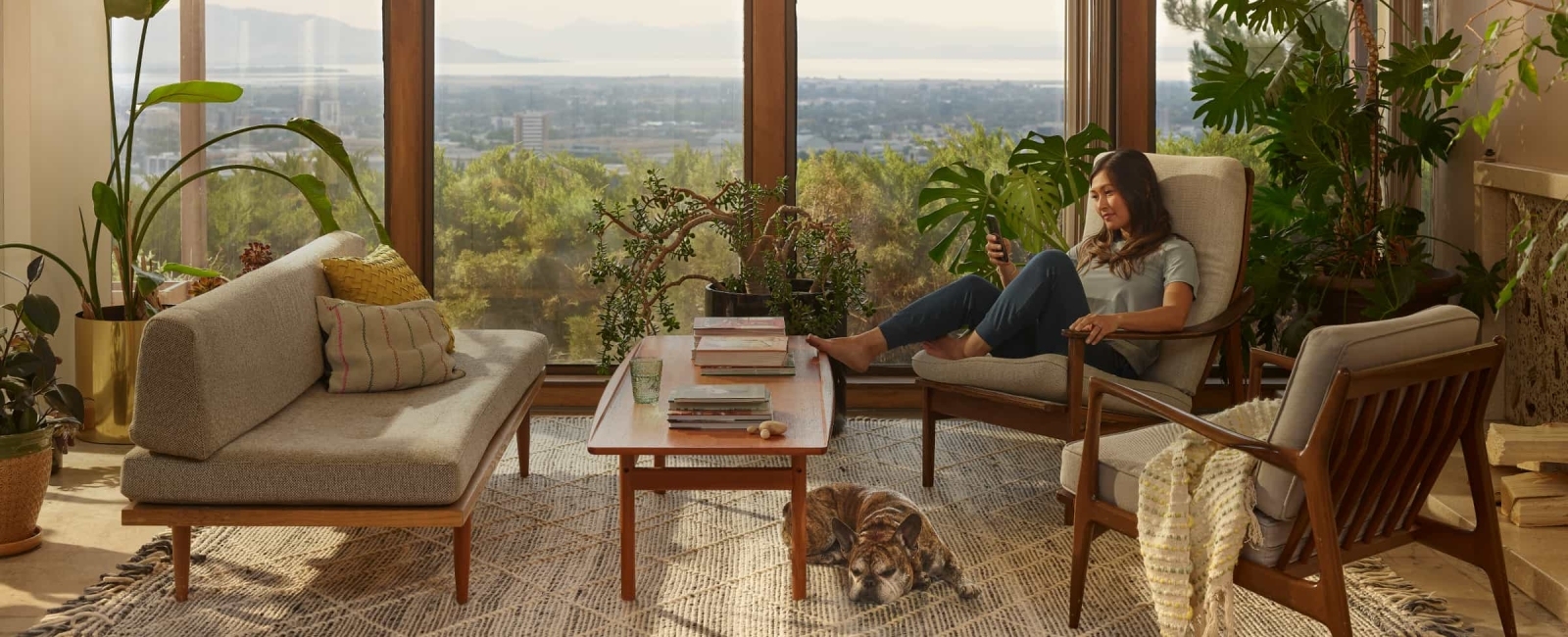 Woman sitting on her couch looking at her phone