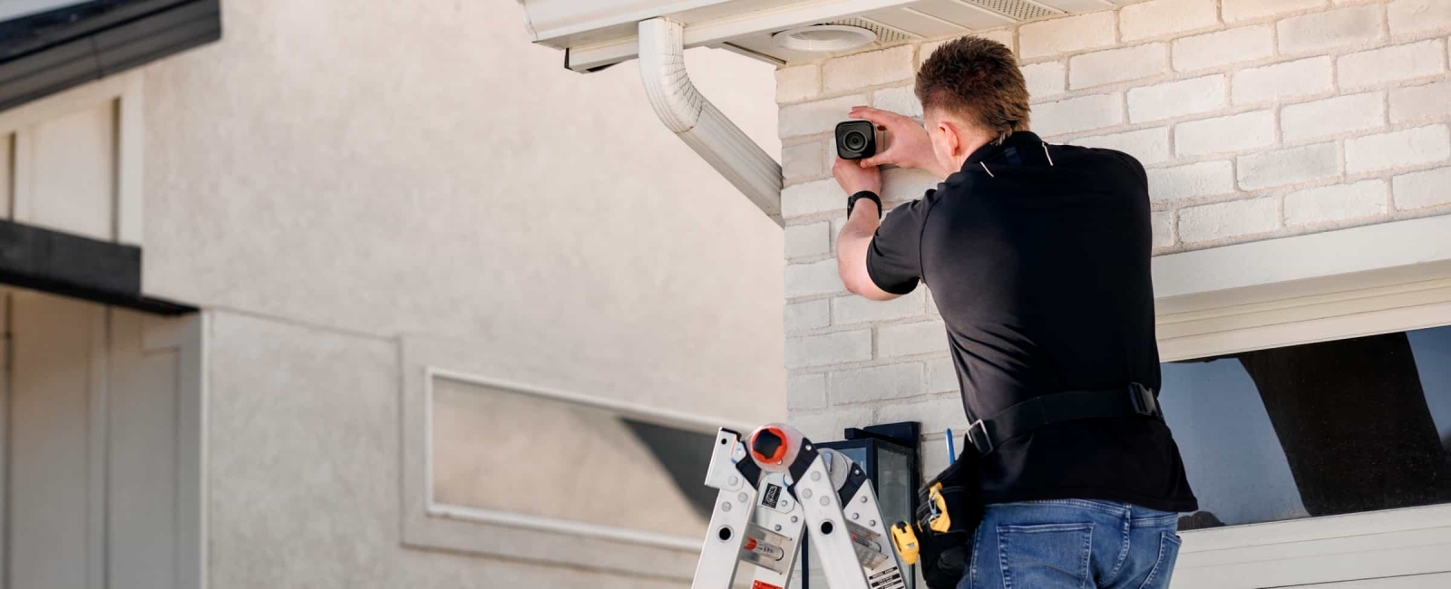 Smart Home Pro standing on a ladder installing a Vivint Outdoor Camera Pro