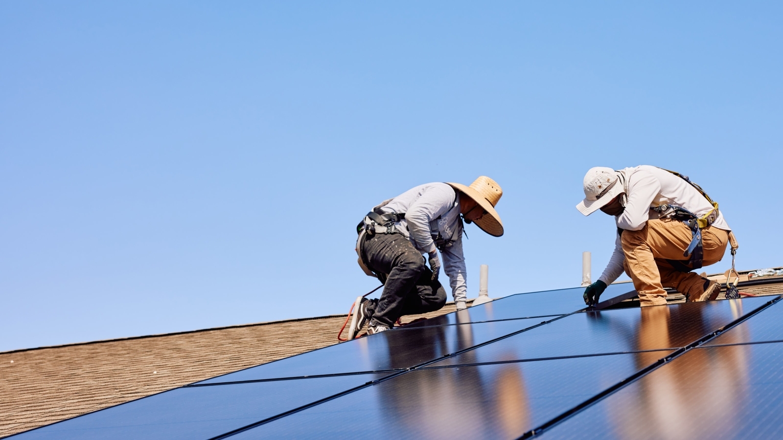 2 smart home pros installing solar panels on roof