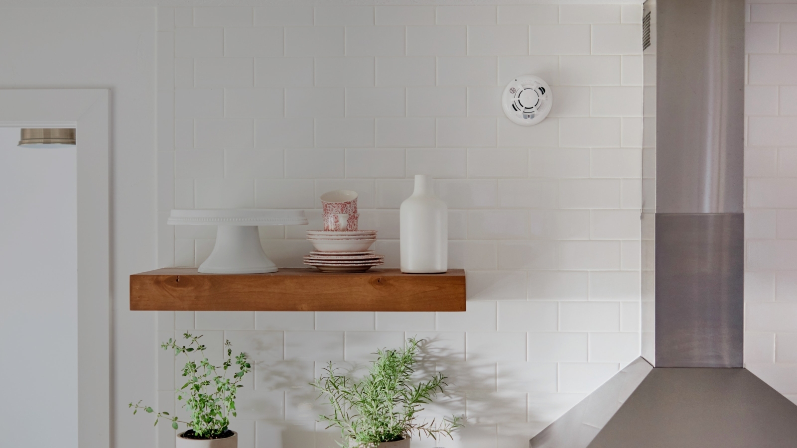 Vivint safety alarm on the wall with vases on a shelf