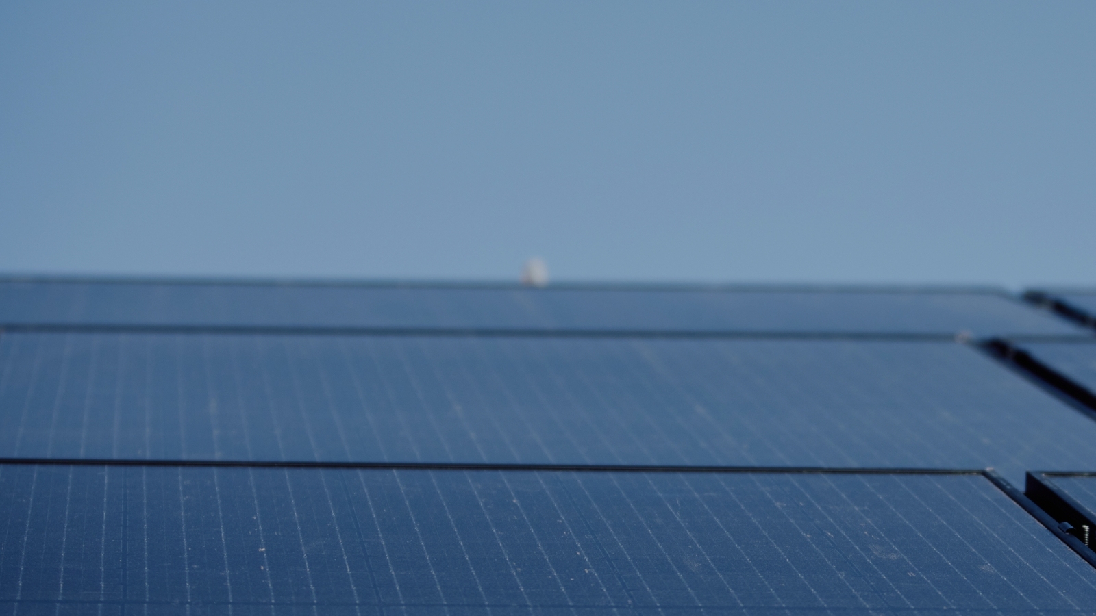 Close up slanted view of installed solar panels and blue sky