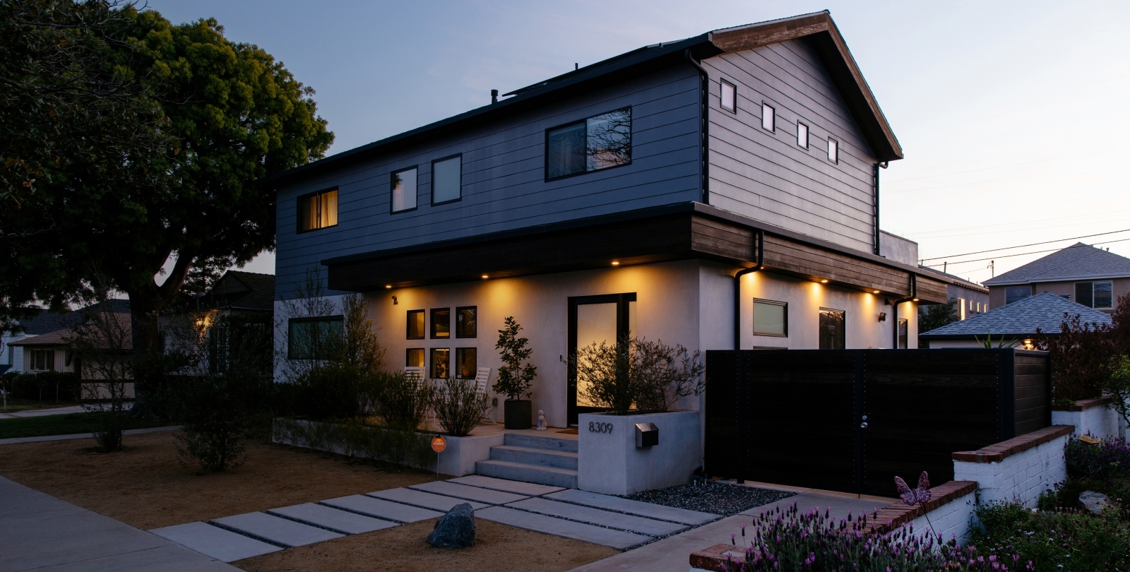 Two story home with yellow exterior lights on
