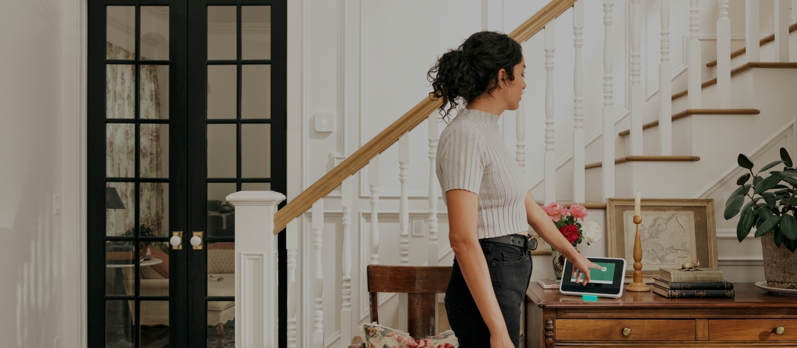 A Woman using Vivint Smart Hub on a desk next to the stairs