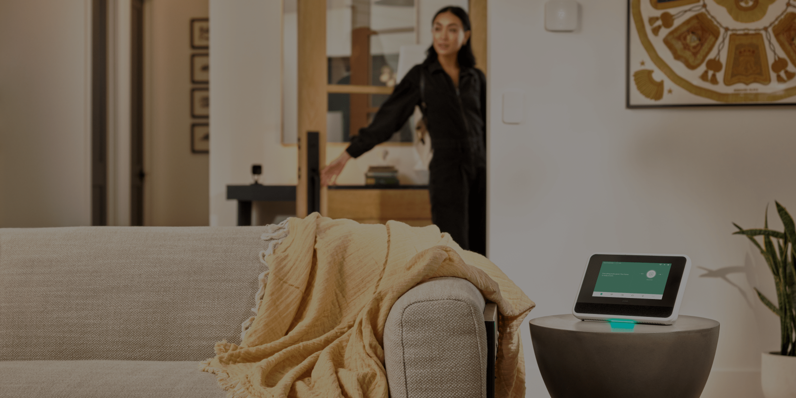 A woman entering the room with Vivint Hub on the desk