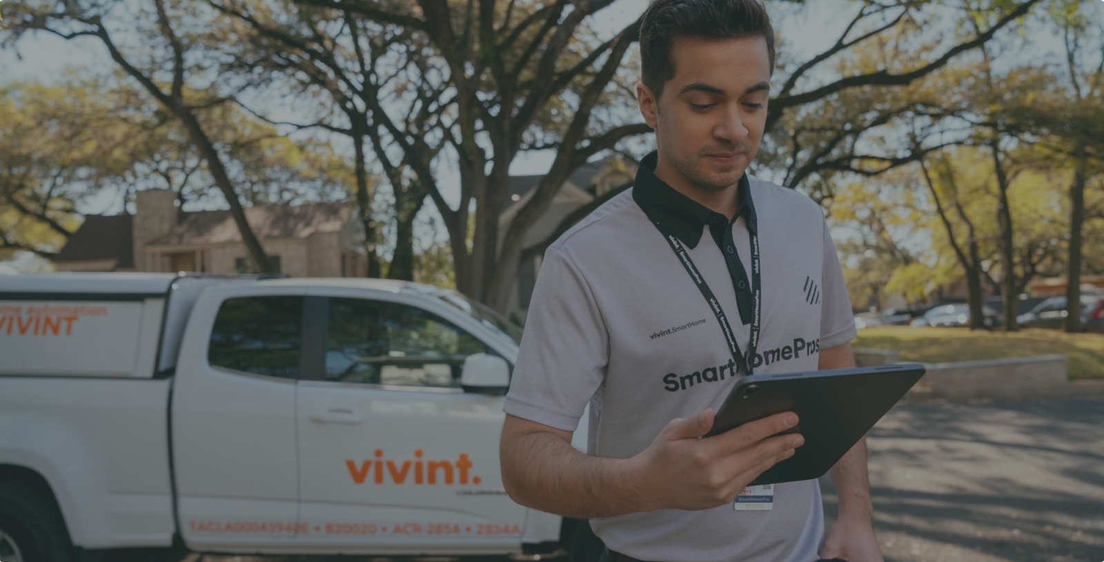 Vivint Smart Home Professional reviewing work order on tablet outside of his truck
