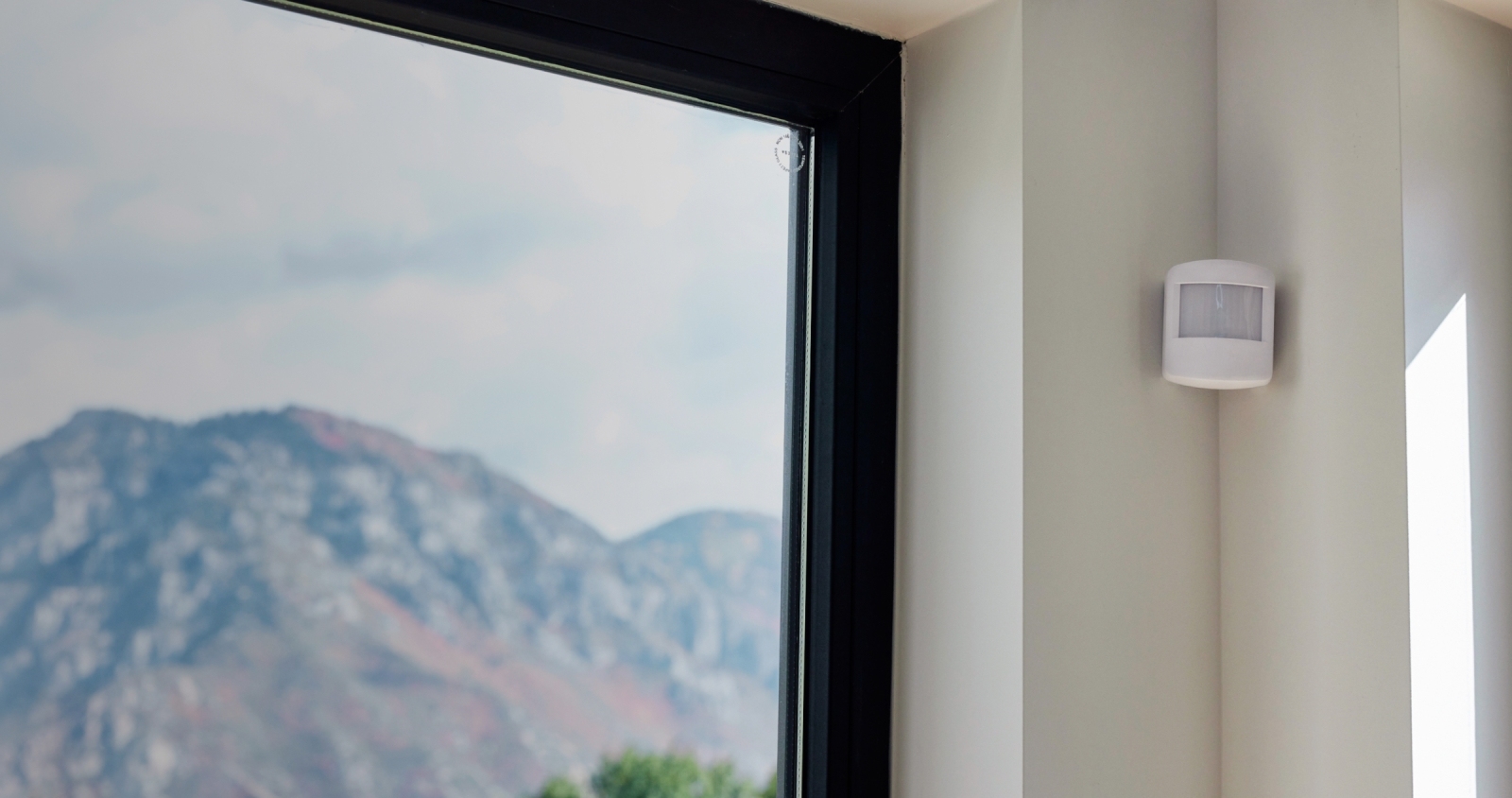 Sensor de movimiento Vivint instalado y vista de montañas por la ventana