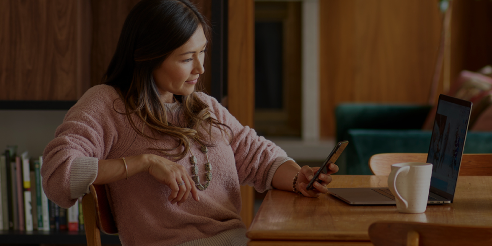 Woman sitting at a table checking her phone