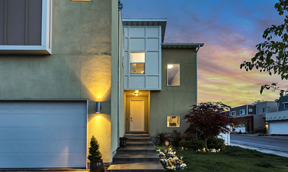A home's exterior lit up with smart lighting.