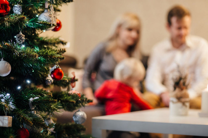 Family sitting by a Christmas tree.