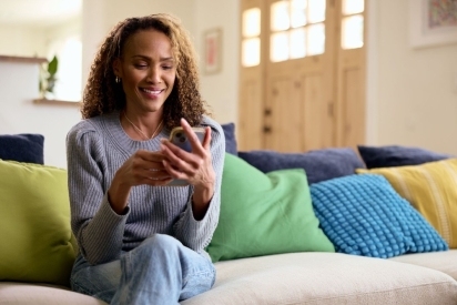 Woman smiling at her phone.