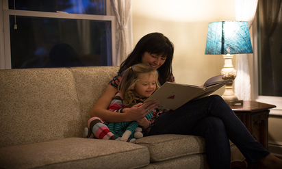 Woman reading to a toddler.