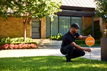 Vivint Smart Home Pro installing a yard sign.