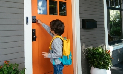 Child entering the code into a Kwikset Smart Lock from Vivint.