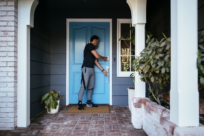 Man activating his smart lock as he leaves the house.