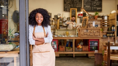 Business owner standing in front of their shop.