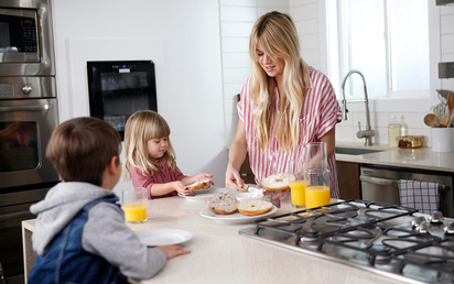A mother with her kids in the kitchen.