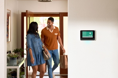 Couple coming home with a Smart Hub on their wall.