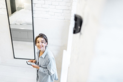 Woman looking at a motion detector on her wall.