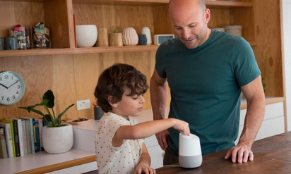 Father and son using a Google smart assistant.