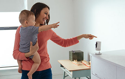 Mother and baby speaking into the Vivint Indoor Camera Pro.